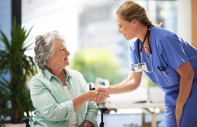 Family member and assisted living resident talking quietly in a bright common room.